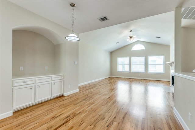 interior space with visible vents, a ceiling fan, light wood-style flooring, and vaulted ceiling