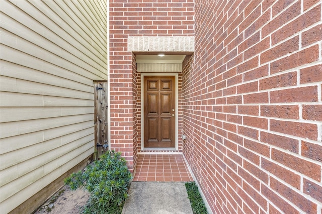 view of exterior entry with brick siding