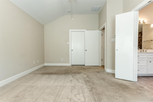 unfurnished bedroom with baseboards, visible vents, carpet floors, and vaulted ceiling