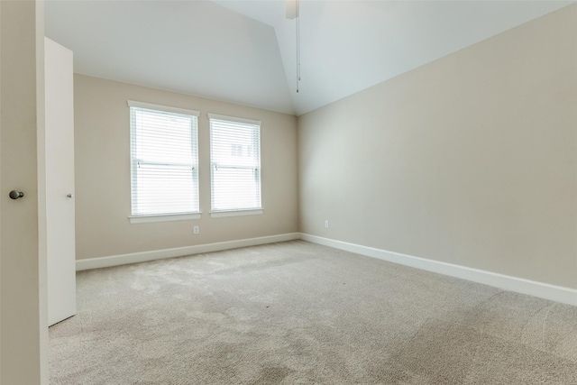 carpeted spare room featuring baseboards, ceiling fan, and lofted ceiling