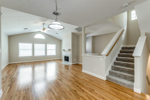 unfurnished living room featuring visible vents, plenty of natural light, a ceiling fan, and light wood-style floors