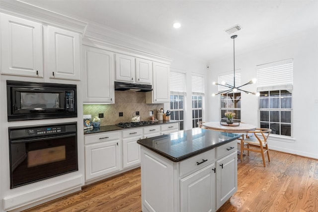 kitchen featuring visible vents, white cabinetry, a chandelier, backsplash, and black appliances