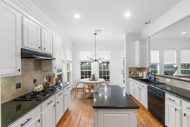 kitchen featuring under cabinet range hood, a chandelier, tasteful backsplash, a sink, and black appliances
