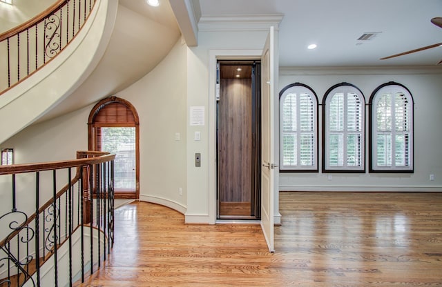 foyer entrance with visible vents, crown molding, and baseboards