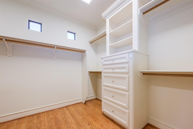 walk in closet with light wood-style flooring