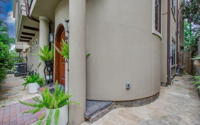 exterior space with a patio area, central AC unit, stucco siding, and fence