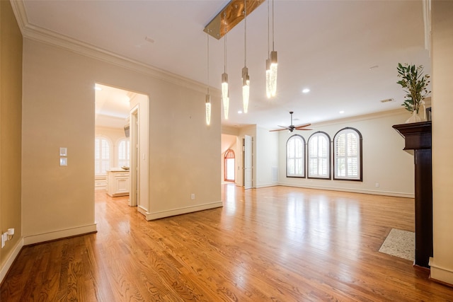 unfurnished living room featuring light wood-style flooring, crown molding, baseboards, and ceiling fan