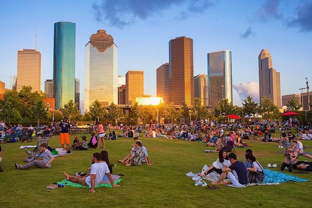 view of property's community featuring a city view and a lawn