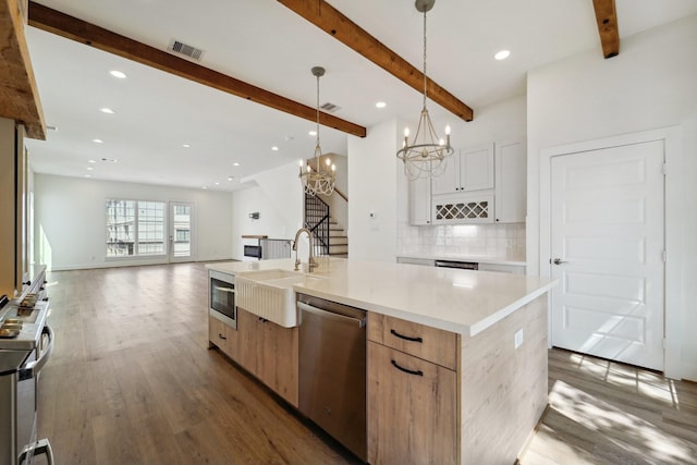 2520 Ohsfeldt St, Houston, TX 77008 - kitchen with stainless steel appliances, a sink, decorative backsplash, beam ceiling, and wood finished floors