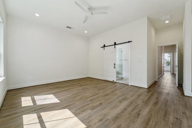 2520 Ohsfeldt St, Houston, TX 77008 - empty room with a barn door, a ceiling fan, wood finished floors, baseboards, and recessed lighting