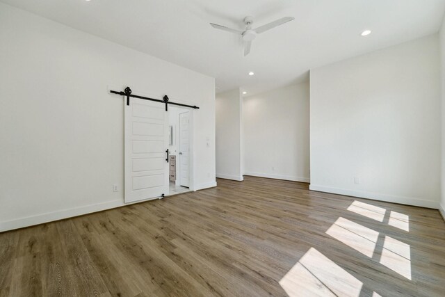 2520 Ohsfeldt St, Houston, TX 77008 - empty room with a barn door, wood finished floors, ceiling fan, baseboards, and recessed lighting