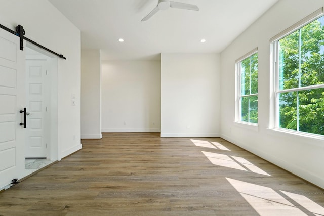 2520 Ohsfeldt St, Houston, TX 77008 - spare room with a barn door, wood finished floors, a ceiling fan, baseboards, and recessed lighting