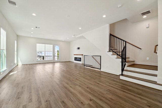 2520 Ohsfeldt St, Houston, TX 77008 - unfurnished living room featuring wood finished floors, stairway, baseboards, recessed lighting, and a glass covered fireplace