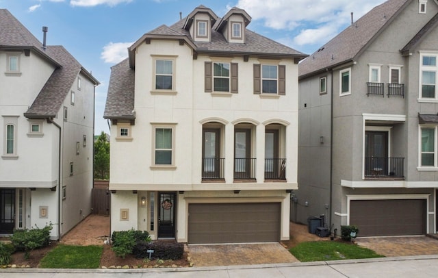 view of front of property featuring an attached garage, decorative driveway, and stucco siding