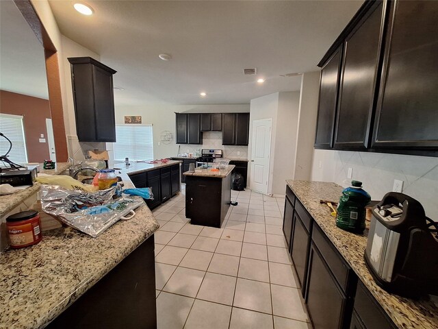 211 Sea Breeze Dr, Bacliff, TX 77518 - kitchen with light tile patterned flooring, tasteful backsplash, visible vents, light stone counters, and stainless steel range with electric stovetop