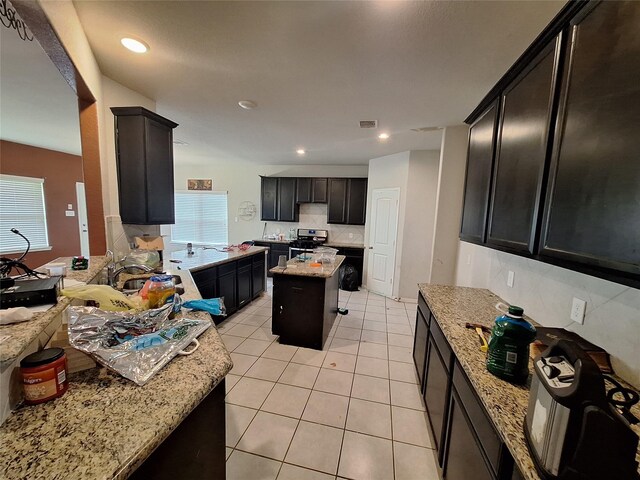 211 Sea Breeze Dr, Bacliff, TX 77518 - kitchen featuring light stone counters, stainless steel range, light tile patterned floors, backsplash, and visible vents