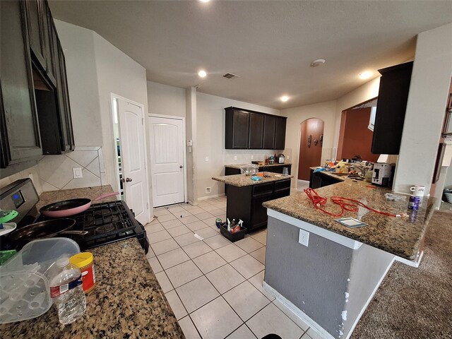211 Sea Breeze Dr, Bacliff, TX 77518 - kitchen with light stone countertops, gas range oven, visible vents, and arched walkways
