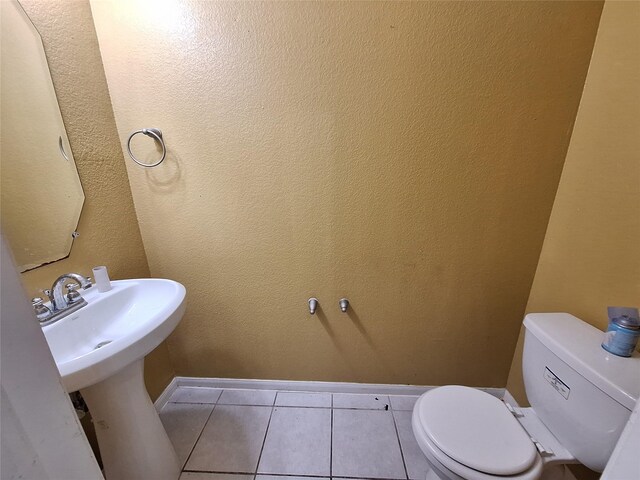 211 Sea Breeze Dr, Bacliff, TX 77518 - half bath featuring toilet, tile patterned flooring, a sink, and baseboards