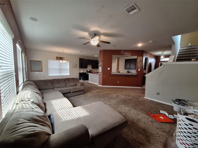 211 Sea Breeze Dr, Bacliff, TX 77518 - carpeted living room featuring baseboards, stairs, visible vents, and ceiling fan with notable chandelier