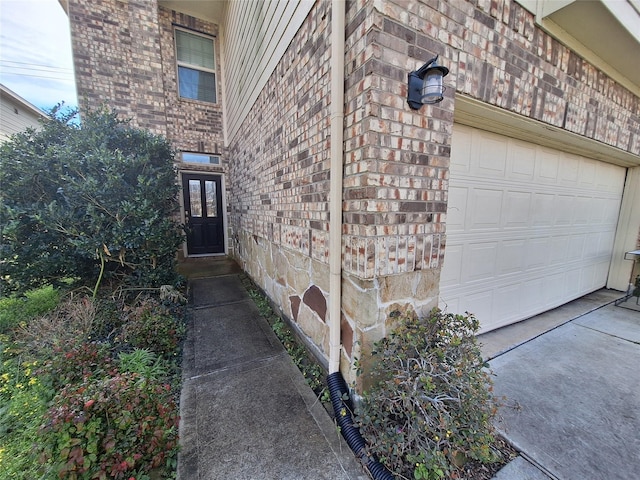 211 Sea Breeze Dr, Bacliff, TX 77518 - doorway to property featuring concrete driveway, an attached garage, and brick siding