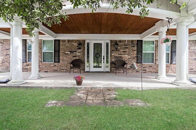 exterior space with a lawn, brick siding, and covered porch