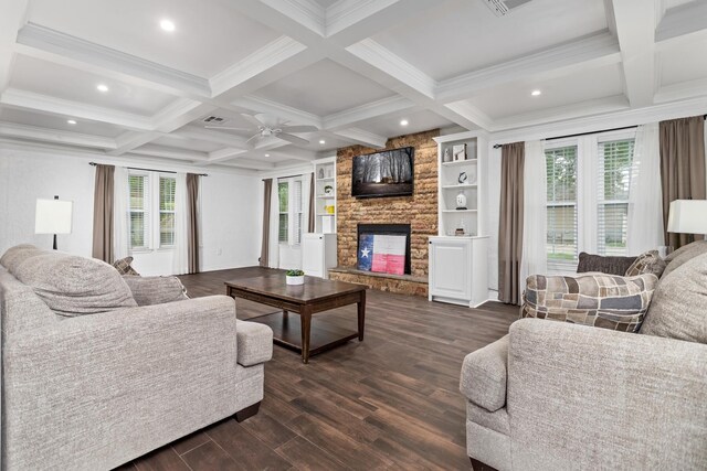 living room featuring plenty of natural light, a stone fireplace, coffered ceiling, and dark wood-style flooring