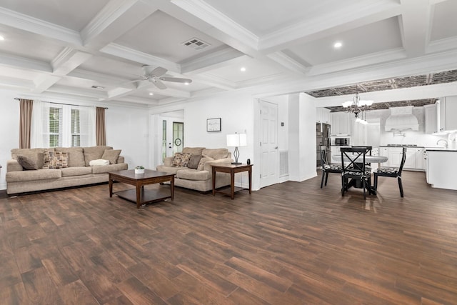 living room featuring ceiling fan with notable chandelier, visible vents, coffered ceiling, and dark wood-style flooring