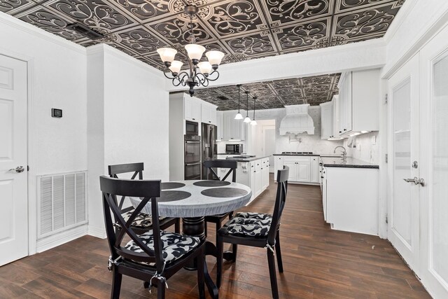 dining room with an ornate ceiling, crown molding, a chandelier, visible vents, and dark wood-style floors