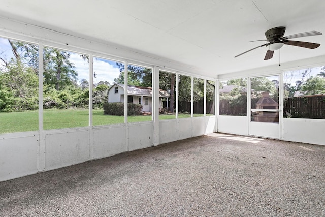 unfurnished sunroom featuring ceiling fan and plenty of natural light
