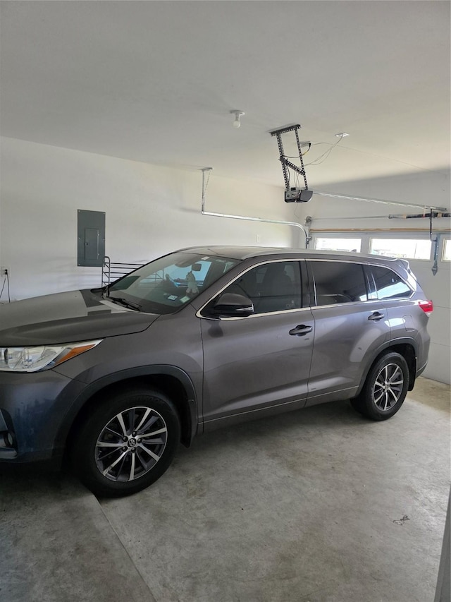 garage with a garage door opener and electric panel
