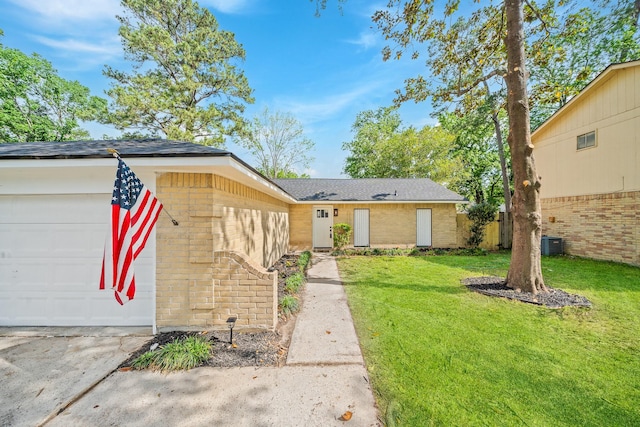 single story home with brick siding, an attached garage, a front lawn, and central AC unit