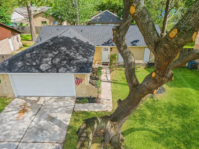 view of front facade featuring roof with shingles, a front lawn, driveway, fence, and a garage