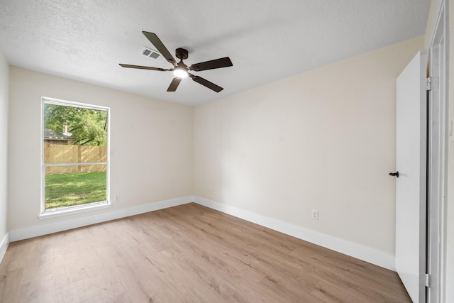 spare room featuring baseboards, wood finished floors, visible vents, and a ceiling fan