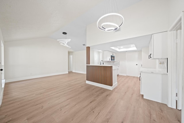 unfurnished living room featuring lofted ceiling, light wood-style flooring, baseboards, and visible vents