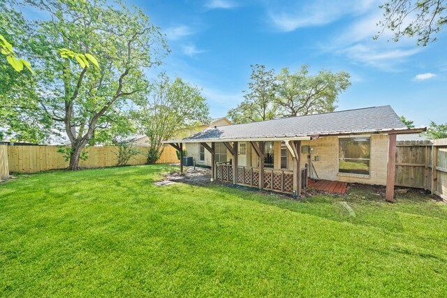 rear view of house featuring a fenced backyard, a patio, and a lawn