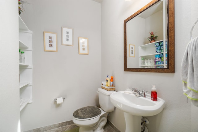 bathroom with toilet, baseboards, and a sink