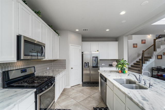 kitchen featuring visible vents, appliances with stainless steel finishes, white cabinetry, and a sink