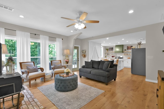 living area with ceiling fan, light wood finished floors, visible vents, and recessed lighting