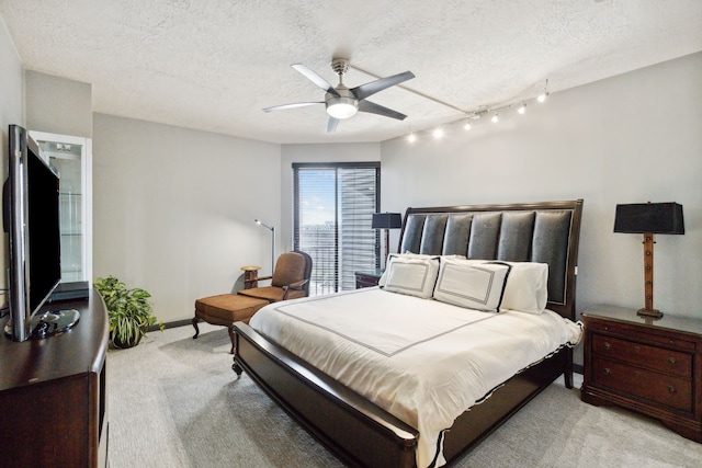 bedroom featuring baseboards, a ceiling fan, a textured ceiling, and light colored carpet