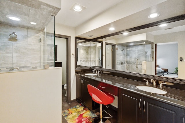 full bathroom with a stall shower, recessed lighting, a sink, and double vanity