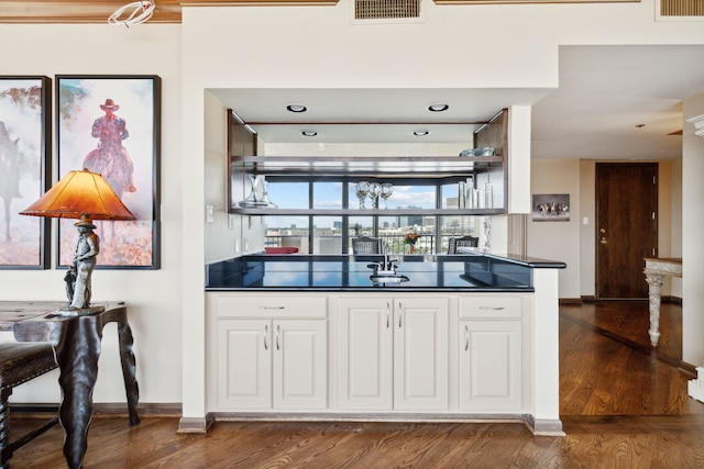 bar with visible vents, dark wood finished floors, and baseboards