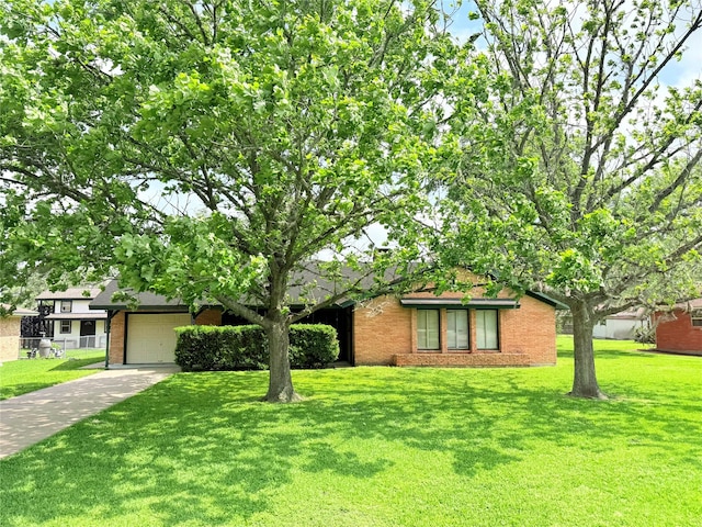 single story home with driveway, brick siding, a front yard, and a garage