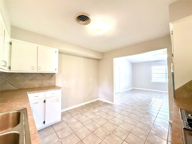 1206 Kent St, Sweeny, TX 77480 - kitchen with light countertops, visible vents, a sink, light tile patterned floors, and decorative backsplash