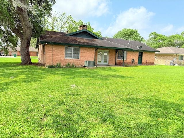 1206 Kent St, Sweeny, TX 77480 - back of property with french doors, a yard, central air condition unit, and brick siding