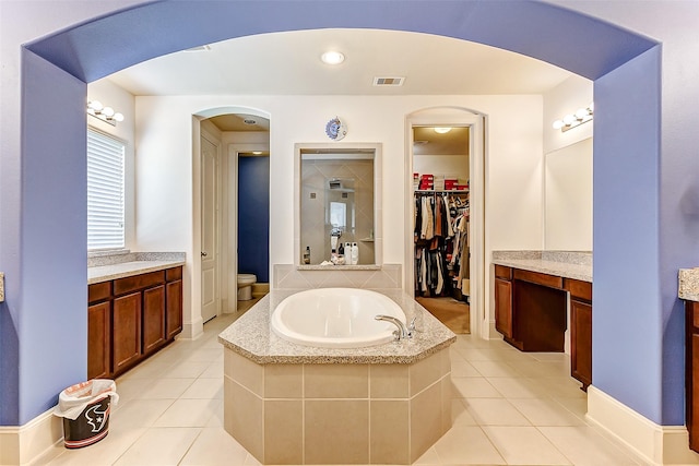bathroom with a bath, visible vents, tile patterned floors, and vanity