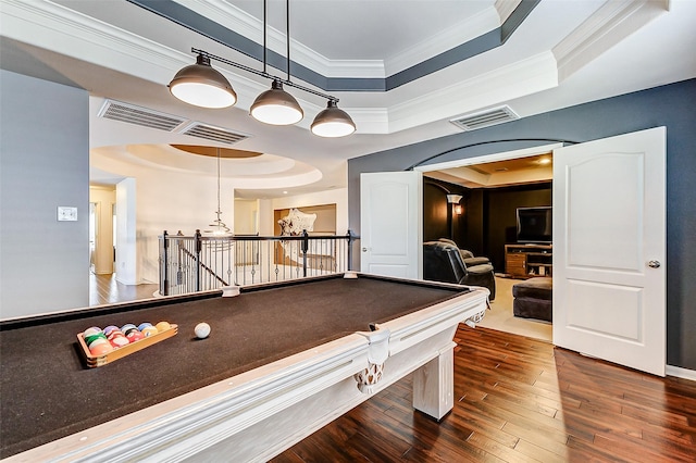 game room featuring a tray ceiling, arched walkways, visible vents, and crown molding