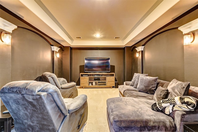 carpeted home theater featuring a tray ceiling, visible vents, and decorative columns