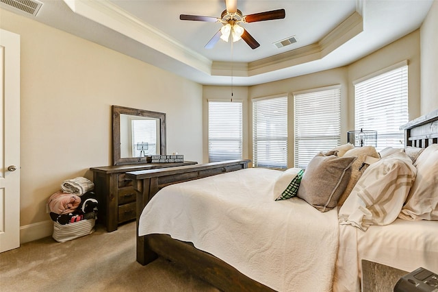 bedroom with a raised ceiling, carpet, visible vents, and crown molding