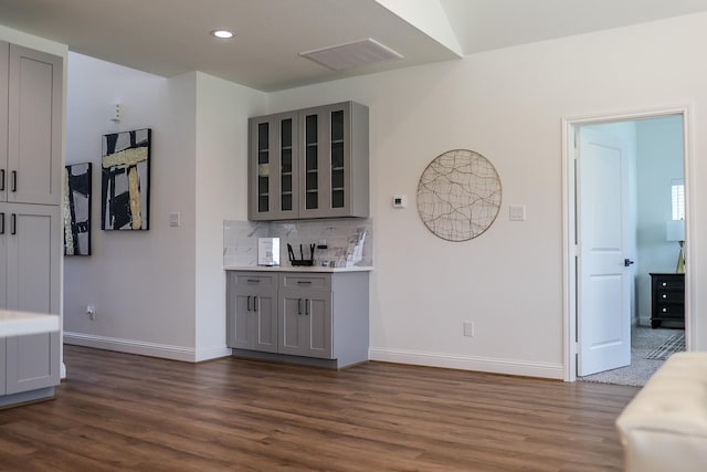 bar with baseboards, dark wood-type flooring, and visible vents