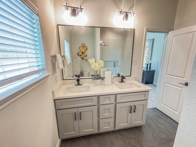 full bath featuring a textured wall, a sink, and a stall shower